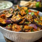 Close-up of aubergines in tamarind sauce with baked halloumi and saffron rice.