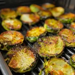 Close-up of freshly cooked green beans in an air fryer basket.