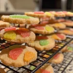 A close-up side view of a juicy melon cookie decorated with colorful sugar.