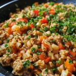A close-up side view of a bowl of One Pot Chicken Bulgur, showcasing colorful vegetables and grains.
