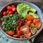 Close-up view of a colorful protein bowl with quinoa, chickpeas, and fresh vegetables.