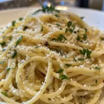 Close-up view of creamy lemon pasta topped with basil.