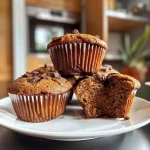 Close-up of a golden-brown Kürbis muffin with a soft texture and visible pumpkin pieces.